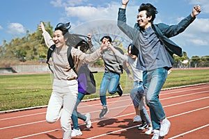 Happy young group students running Across Field