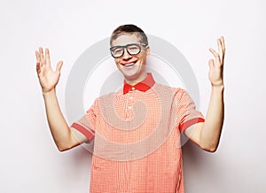 Happy young handsome man gesturing and keeping mouth
