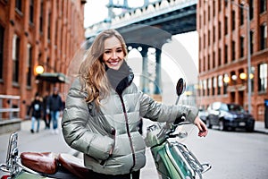 Happy young happy woman travel on vintage scooter around Brooklyn, New York City