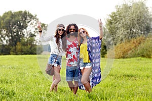 Happy young hippie friends showing peace outdoors