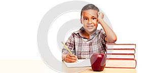Happy Young Hispanic School Boy At Desk with Books and Apple Isolated on a White Background