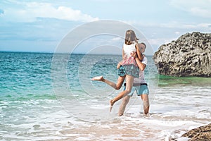 Happy young honeymoon couple having fun on the beach. Ocean, tropical vacation on Bali island, Indonesia.