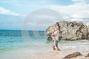 Happy young honeymoon couple having fun on the beach. Ocean, tropical vacation on Bali island, Indonesia.