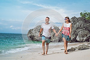 Happy young honeymoon couple walking on the beach. Ocean, tropical vacation on Bali island, Indonesia.