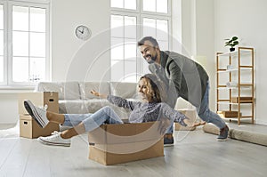 Happy young husband and wife having fun in their newly bought house or apartment