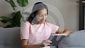 Happy indian Arabic woman in headphones use tablet