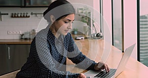 Happy young indian ethnicity woman working on computer.