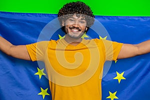 Happy young indian man waving European Union flag, smiling, cheering democratic laws, human rights
