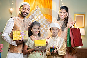 Happy young indian muslim family celebrating and enjoying ramdan festival by shopping online during offer sales -