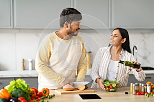 Happy young indian vegetarian couple cooking together at home
