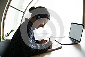 Happy young indian woman enjoying studying remotely from home.