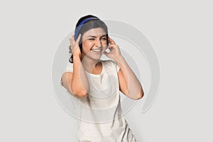 Happy young Indian woman in headphones listen to music