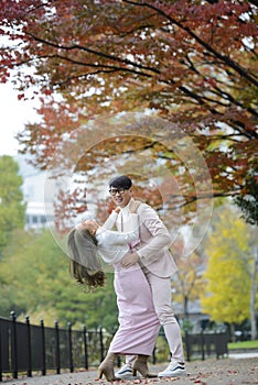 Happy young japanese couple under autumn trees