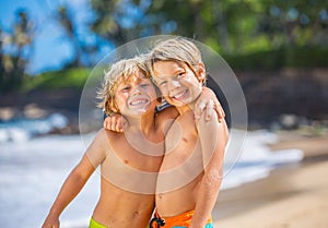 Happy young kids playing at the beach on summer vacation