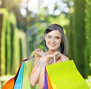 A happy young lady with the colourful shopping bags from the fancy shops.