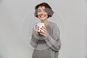 Happy young lady drinking tea.