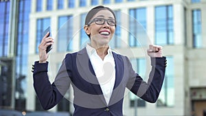 Happy young lady showing success sign, receiving job offer, successful startup