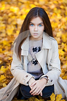 Happy young little girl in beige coat