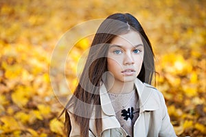 Happy young little girl in beige coat