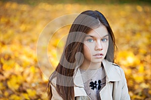 Happy young little girl in beige coat