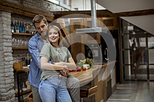 Happy young lovely couple in the kitchen hugging each other