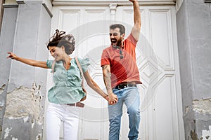 Happy young loving couple having fun and jumping outdoors