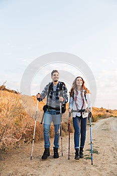 Happy young loving couple outside with backpack in free alternative vacation camping