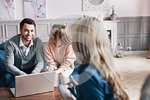 Happy young loving couple sitting together with their financial advisor