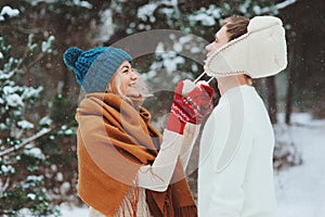 happy young loving couple walking in snowy winter forest, covered with snow and hug