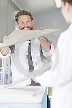 happy young male carpenter looking at wood photo