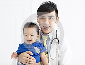 young male doctor holding a baby boy