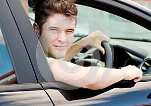 Happy young male driver sitting in his car