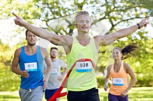 Happy young male runner winning on race finish