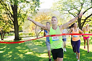 Happy young male runner winning on race finish