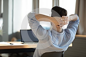 Happy young male worker employee resting on chair during workday. photo