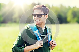 Happy young man with backpack hiking outdoors