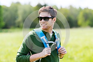 Happy young man with backpack hiking outdoors