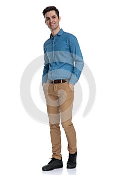 Happy young man in blue shirt looking up and smiling