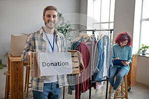 Happy young man with charity box in his hands.