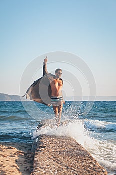 Happy young man dancing on the dock