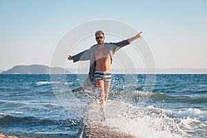 Happy young man dancing on the dock