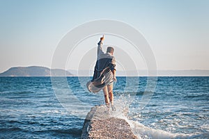 Happy young man dancing on the dock