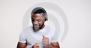 Happy young man dancing while listening music on headphones