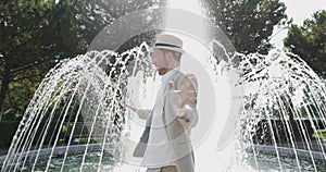 Happy Young Man Dancing in Water Fountain in Summer Time