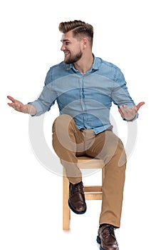 Happy young man in denim shirt smiling and gesticulating photo