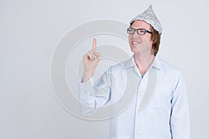 Happy young man doctor with tinfoil hat thinking and pointing up