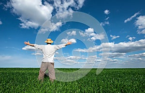 Happy young man on green field of wheat