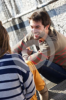 Happy young man having a conversation with woman