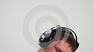 Happy young man in headphones dancing and listen music on white background