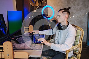 Happy young man in headset with pc computer playing game at home and streaming playthrough. Technology, gaming